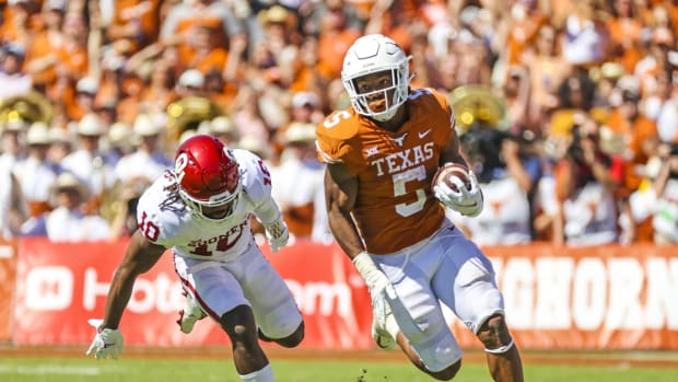 Oct 9, 2021; Dallas, Texas, USA; Texas Longhorns running back Bijan Robinson (5) runs with the ball as Oklahoma Sooners safety Pat Fields (10) defends during the game at the Cotton Bowl. Mandatory Credit: Kevin Jairaj-USA TODAY Sports